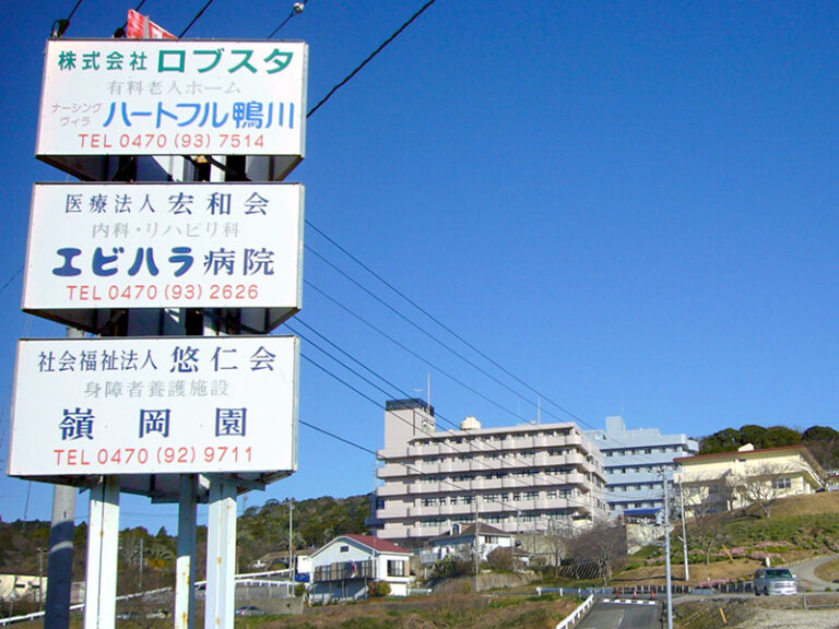 複数の医療・介護施設が入る建物の外観と周辺環境。青空の下に立つ多層階の施設建物。